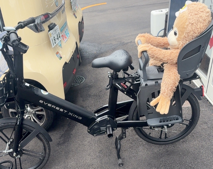チャイルドシート付き自転車にぬいぐるみが乗っている様子